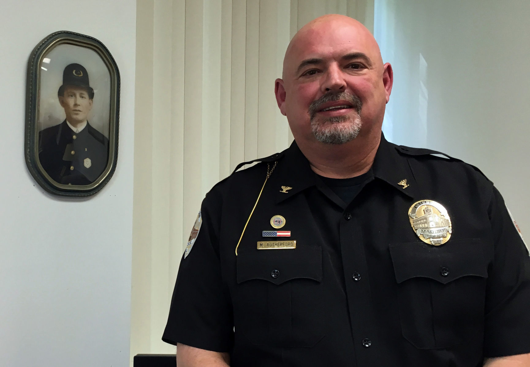 Chief Michael Rutherford beside his great-grandfather's photo